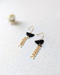 Boucles d’oreilles artisanales noir et or, détail zoomé sur une finition géométrique raffinée