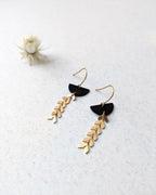 Boucles d’oreilles artisanales noir et or, détail zoomé sur une finition géométrique raffinée