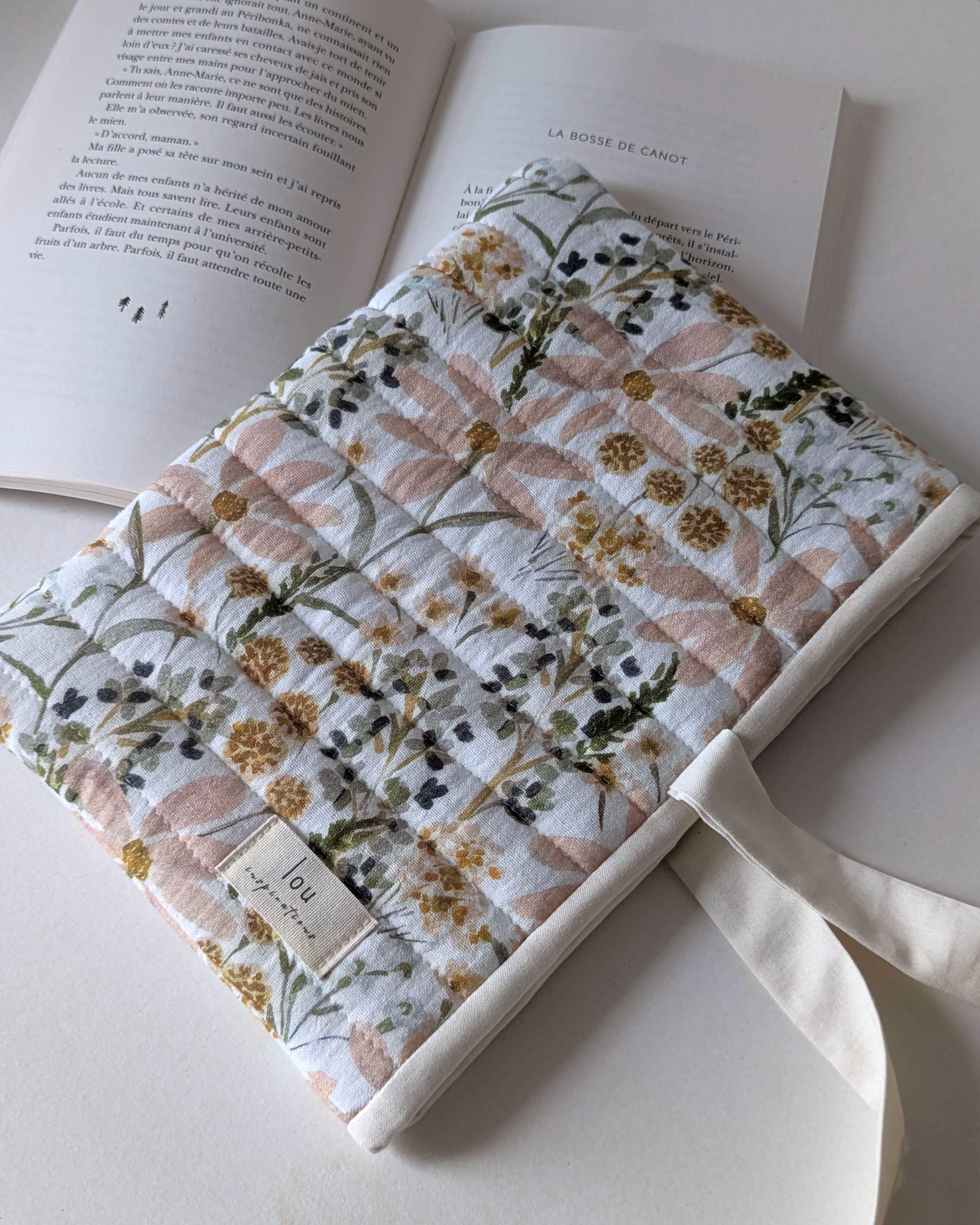 Pochette pour livre matelassée fleurie Champ de fleurs avec lien à nouer, confection artisanale pour protéger les romans et livres.