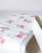 Détail du tissu en gaze de coton écrue avec fleurs roses et beiges utilisé pour la confection de la pochette pour livre artisanale.