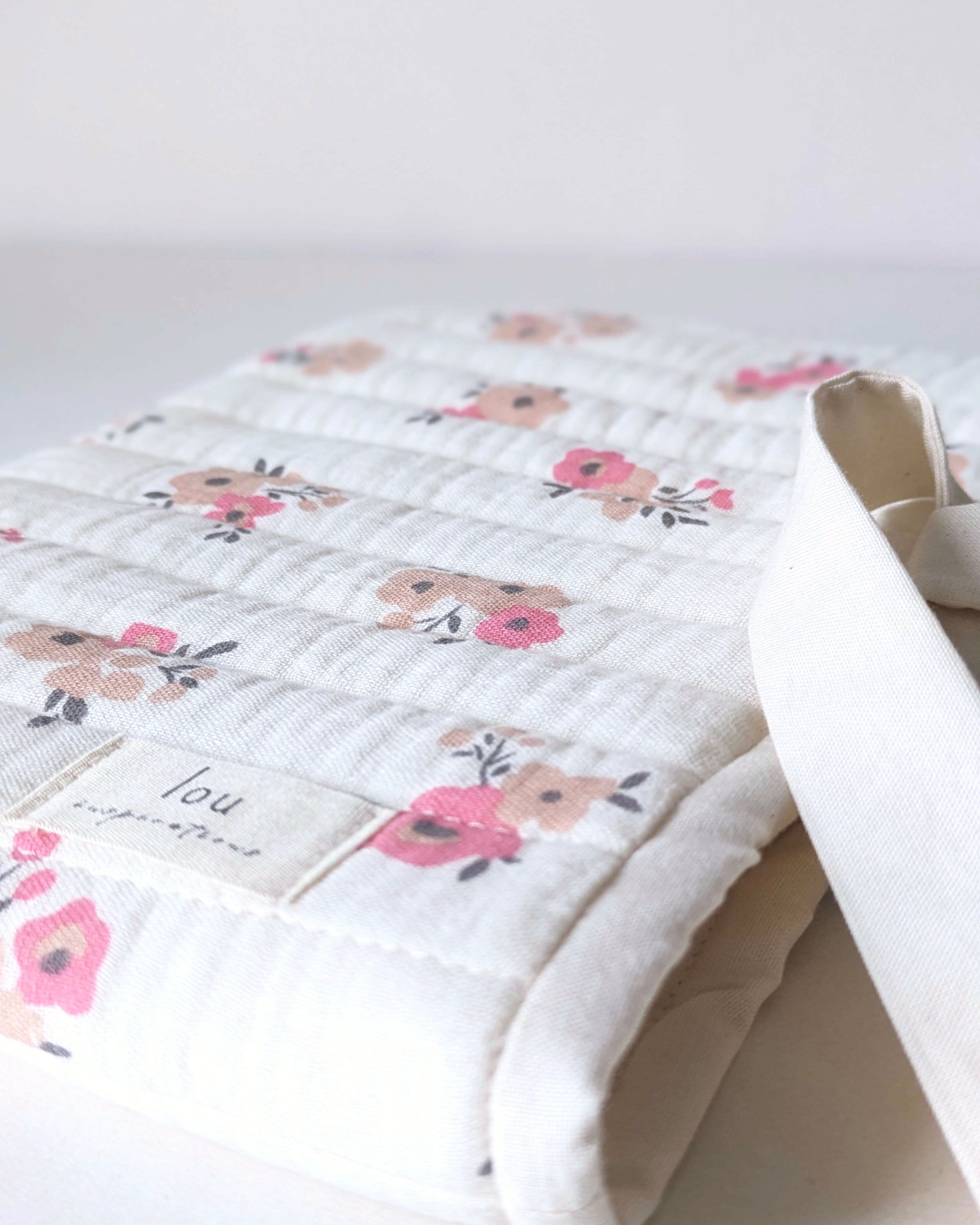 Détail du tissu en gaze de coton écrue avec fleurs roses et beiges utilisé pour la confection de la pochette pour livre artisanale.