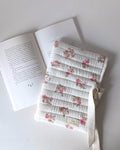 Pochette pour livre matelassée fleurie en gaze de coton écrue avec motif floral rose, confection artisanale pour protéger les romans et livres de poche.