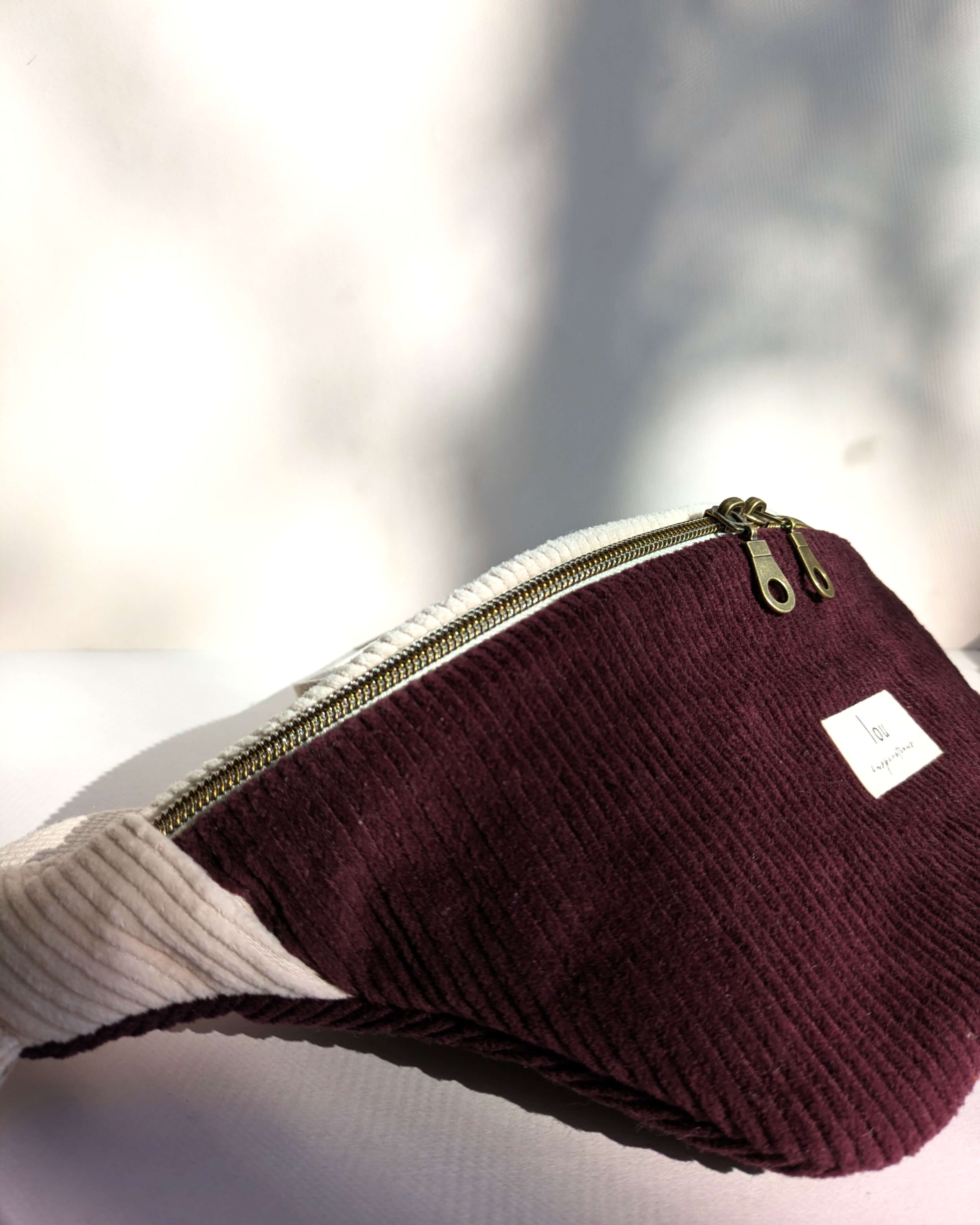 Sac banane bicolore pourpre, création artisanale au style moderne et fonctionnel, détail en gros plan