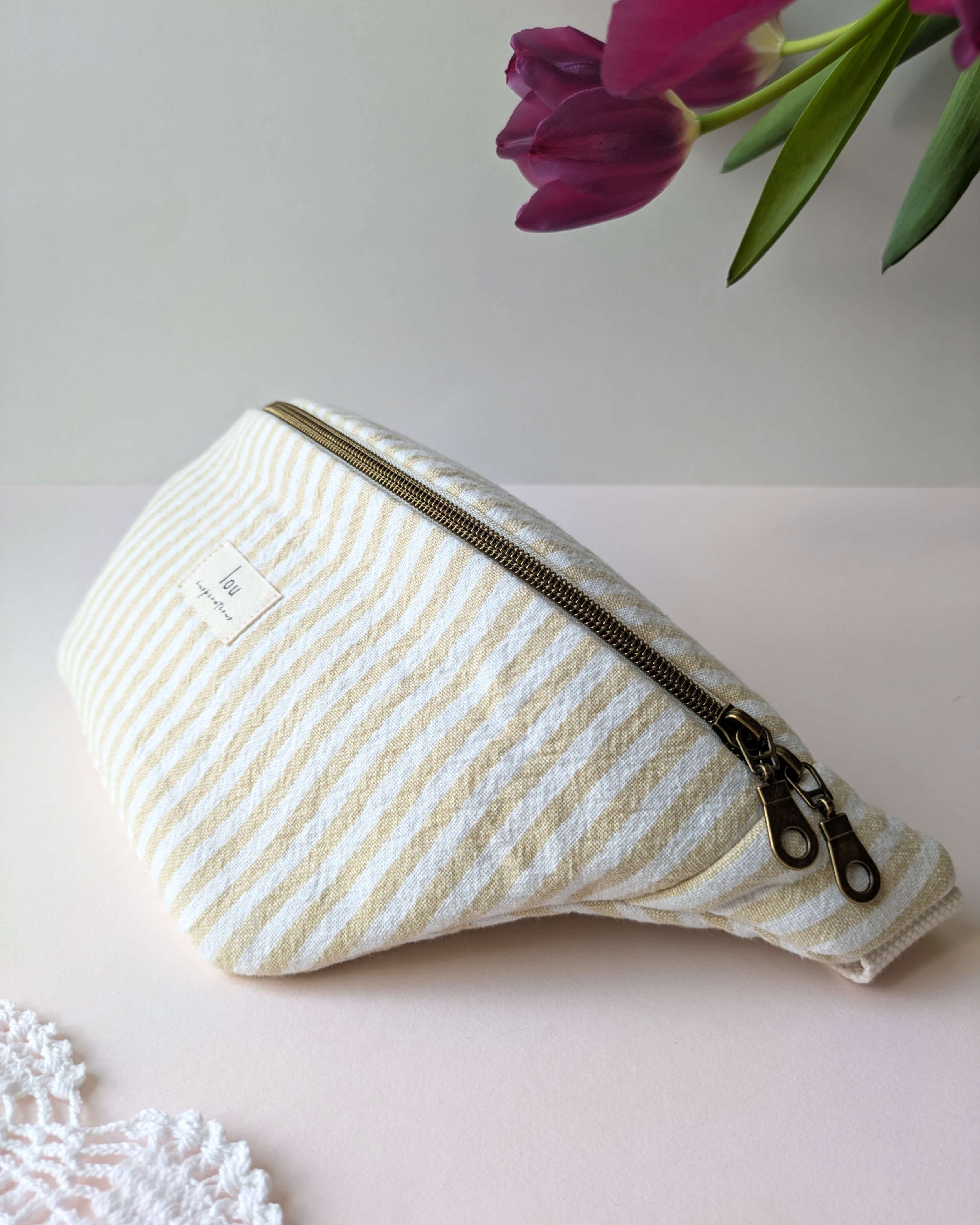 Sac banane rose rayé, détail rapproché sur le textile biologique et le motif estival