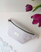 Sac banane rayé rose, création artisanale au style estival léger et fonctionnel, détail en gros plan