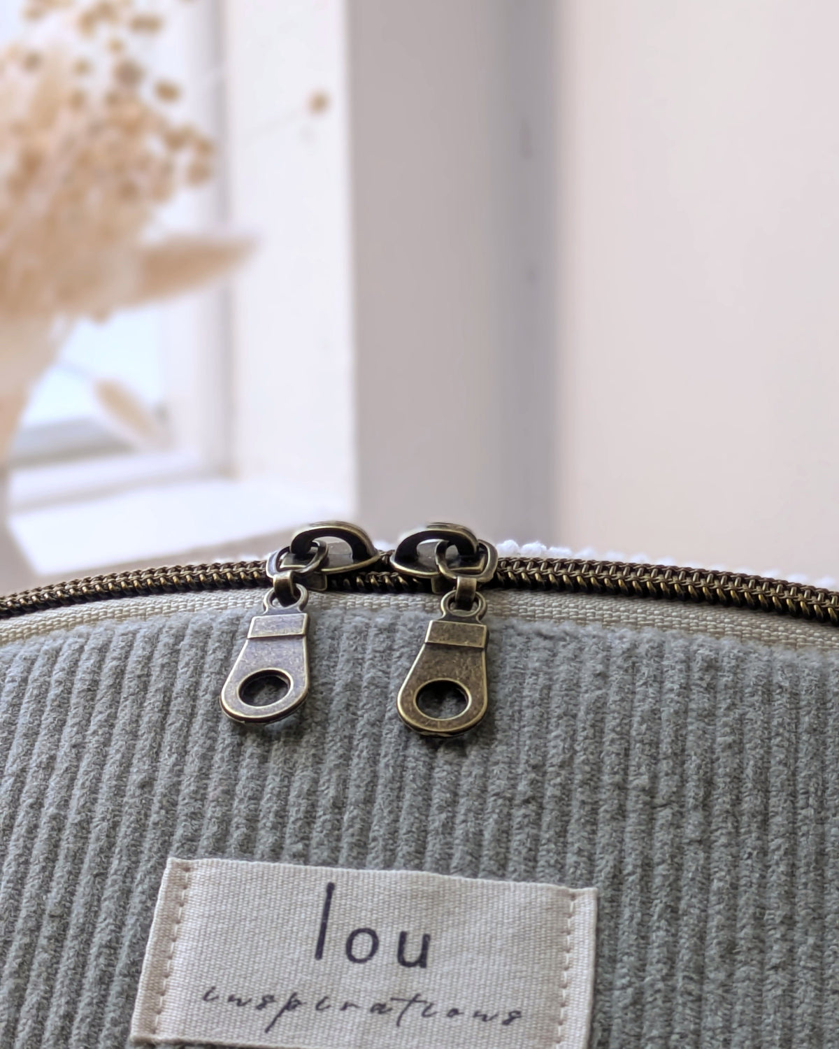 Double tirette de zip en laiton antique sur sac banane en velours côtelé vert sauge, étiquette Lou Inspirations