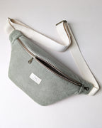 Sac banane en velours côtelé bio sauge avec sangle ajustable crème, double zip bronze et doublure intérieure naturel