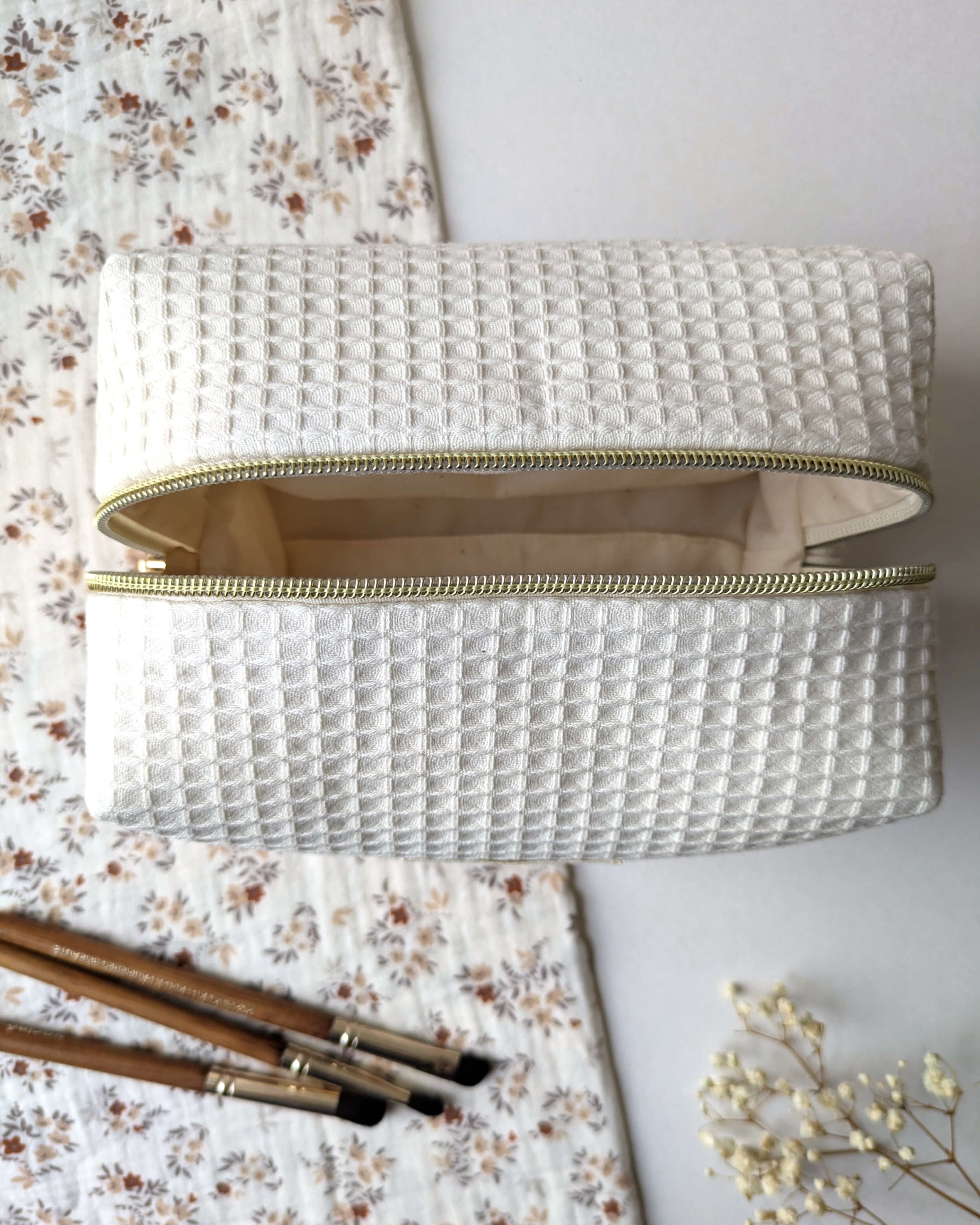 Trousse en tissu gaufré beige création artisanale compacte avec intérieur en coton, pensée pour le rangement du quotidien