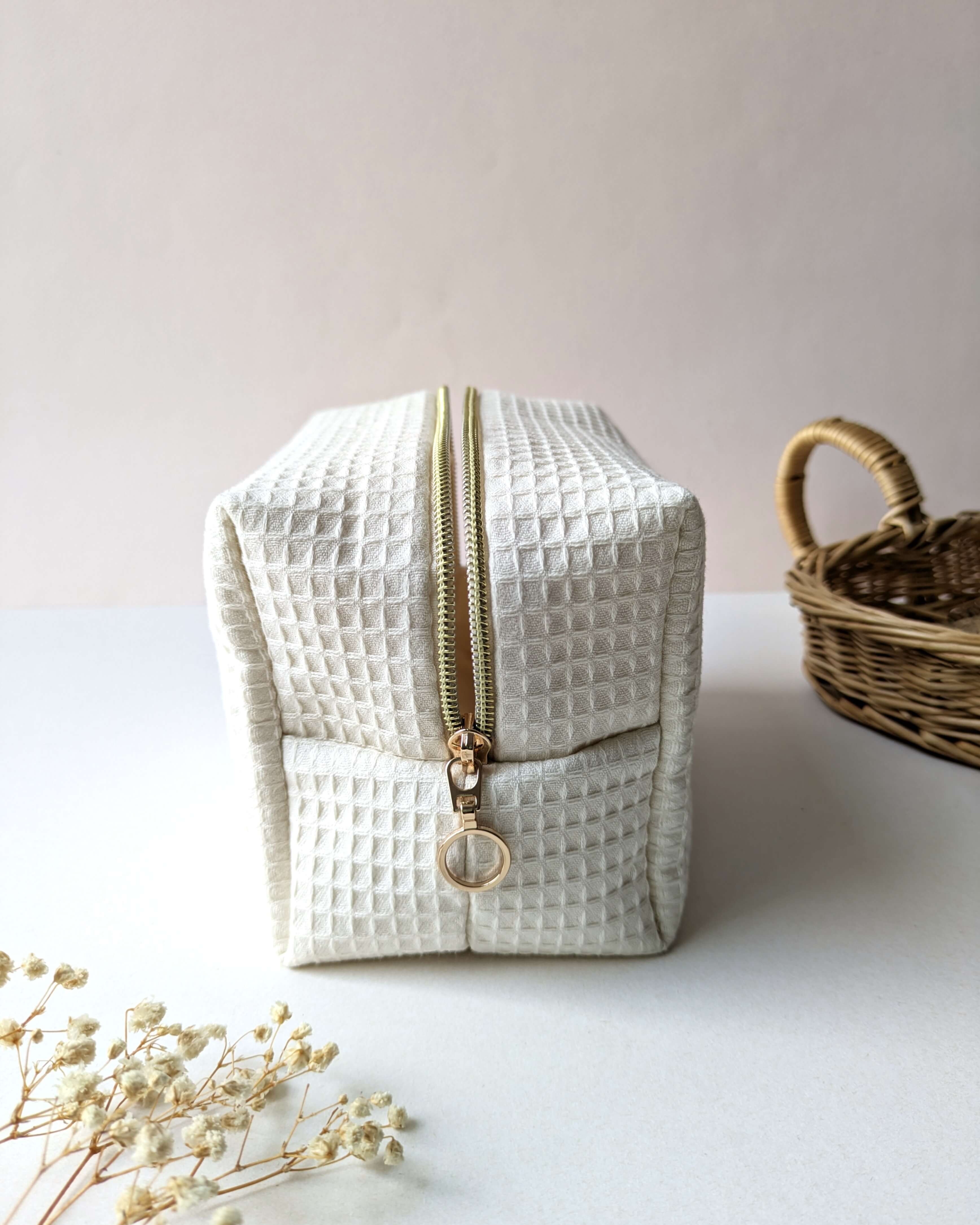 Trousse en tissu gaufré beige, création artisanale compacte avec zip doré résistant, pensée pour le quotidien