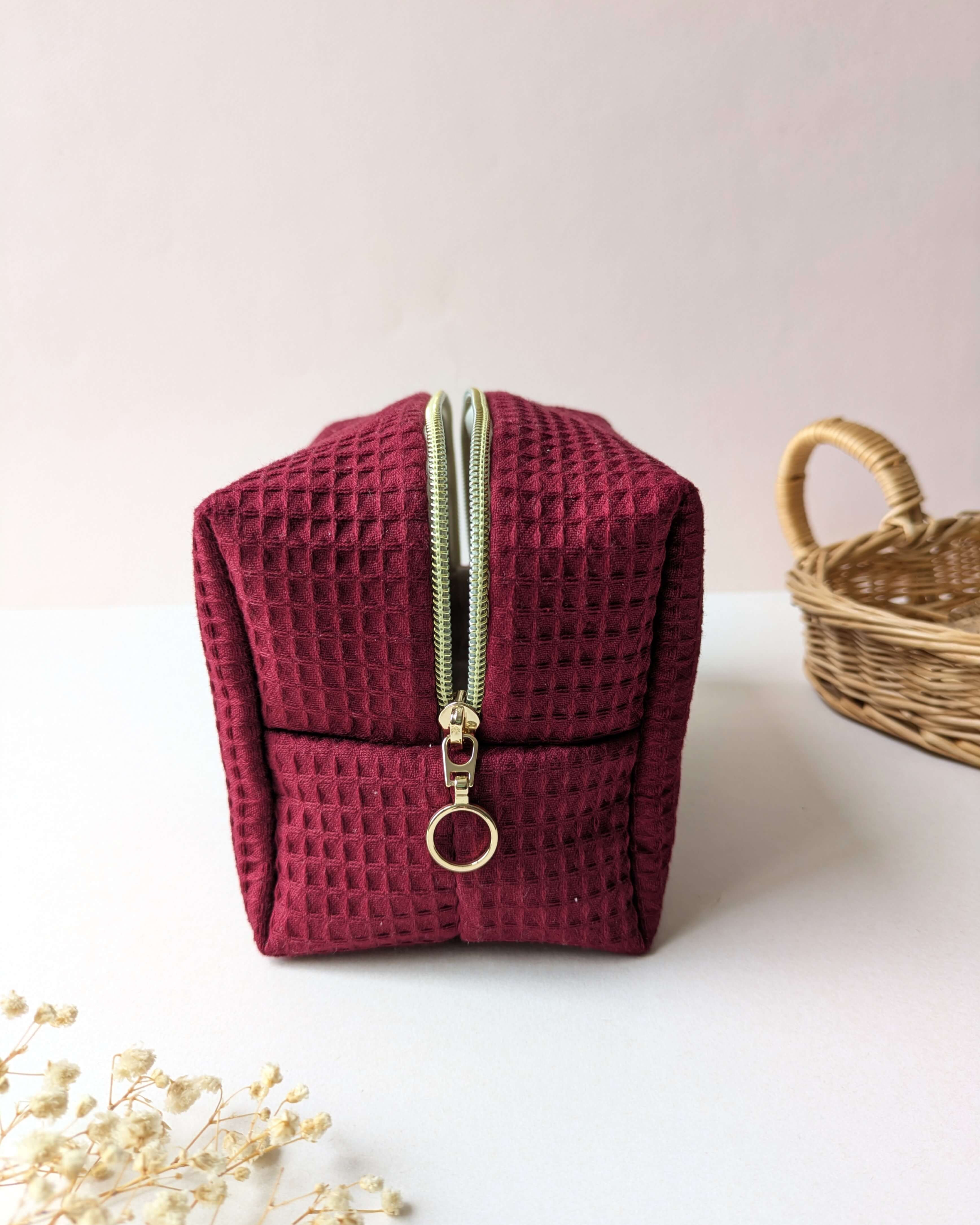 Trousse en tissu gaufré rouge, création artisanale compacte avec zip doré résistant, pensée pour le quotidien